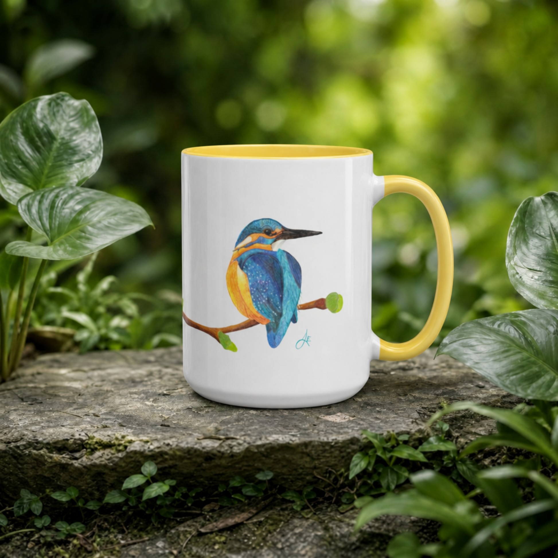 Mug with a kingfisher design on a stone surface with green foliage in the background